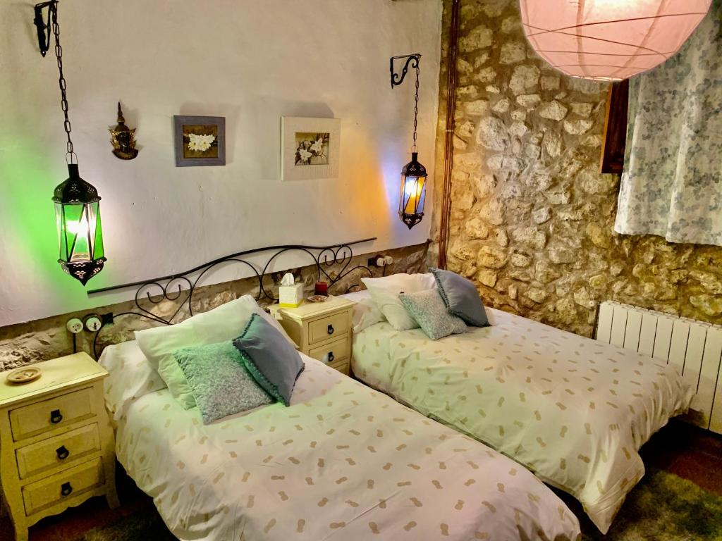 a bedroom with two beds and a table and lights at Casa Tatisita Family in Segura de la Sierra