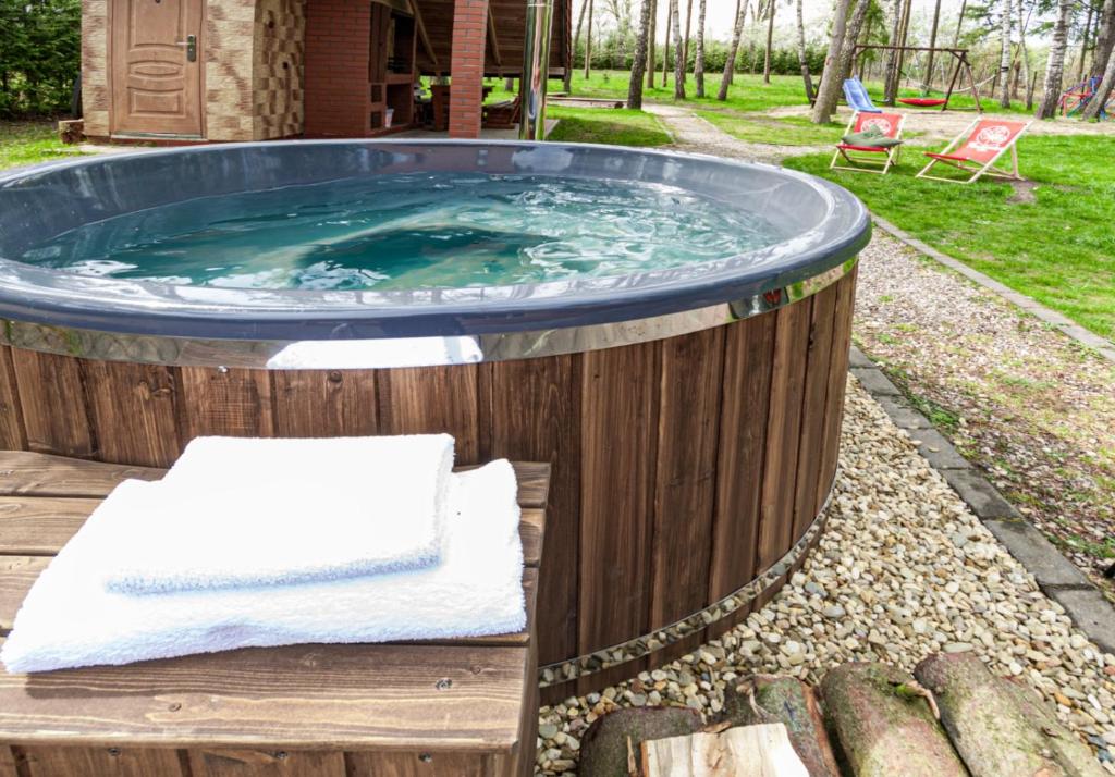 a hot tub in a garden with a bench in front at Willa Poziomka, Mielno, Grunwald in Mielno