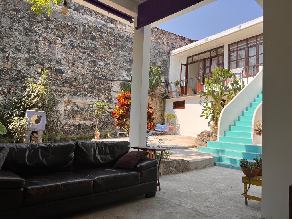 a living room with a couch in front of a brick wall at Catre de mi corazón in Xalapa