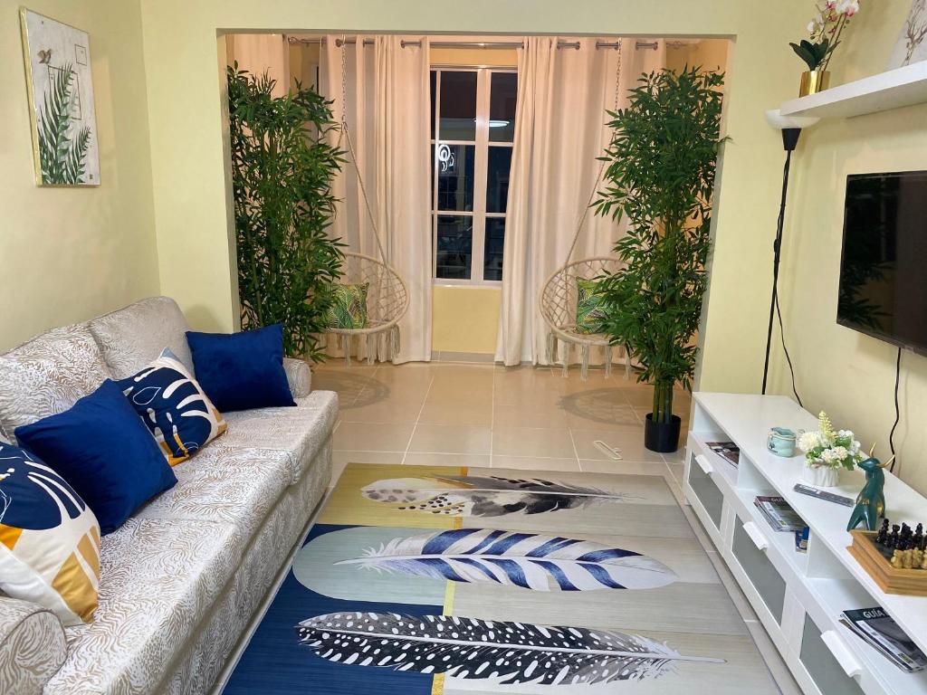 ein Wohnzimmer mit Sofa und blauen Kissen in der Unterkunft Casa Apartamento Valentina in Santo Domingo
