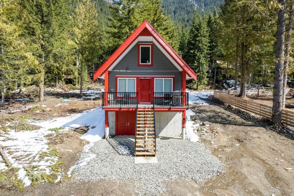 una pequeña casa roja con una puerta roja y escaleras en Brand New 3BR Cabin w/Indoor Fireplace and Laundry, en Sunshine Valley
