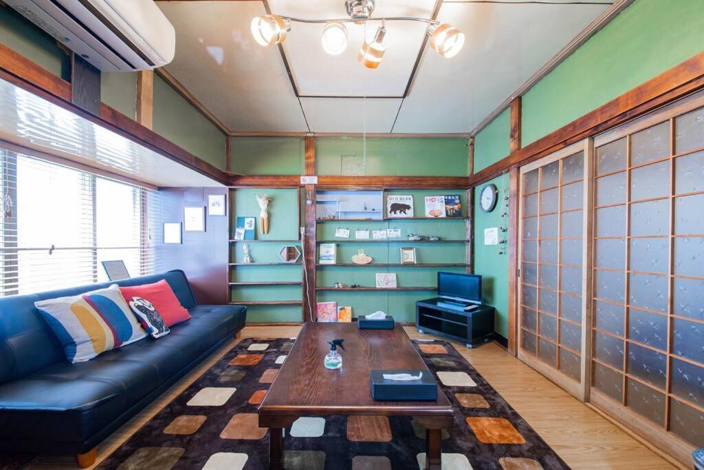 uma sala de estar com um sofá e uma mesa em TARUNE em Otaru