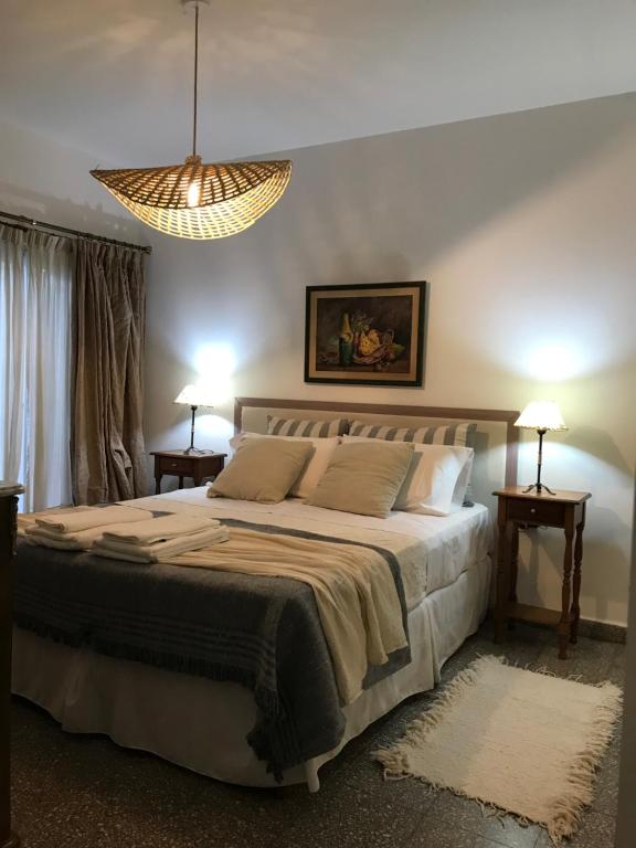 Un dormitorio con una cama grande y una lámpara de araña. en Casa de Piedra- céntrica en La Rioja