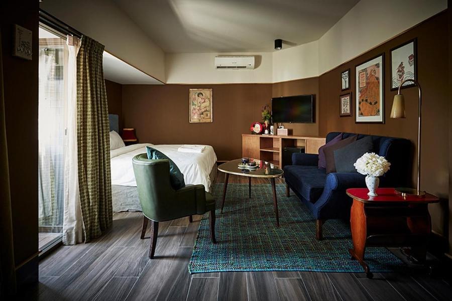 曼谷的住宿－喬希酒店，一间卧室配有一张床、一张沙发和一张桌子