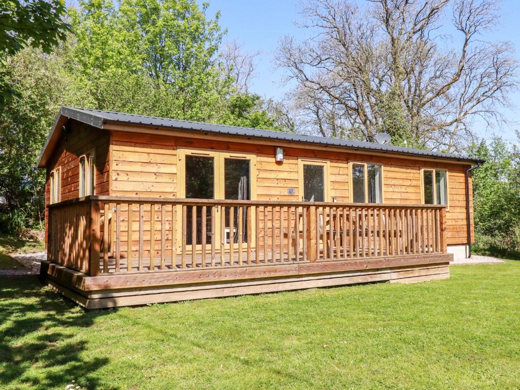 a large wooden cabin with a large deck at Lodge One in Truro