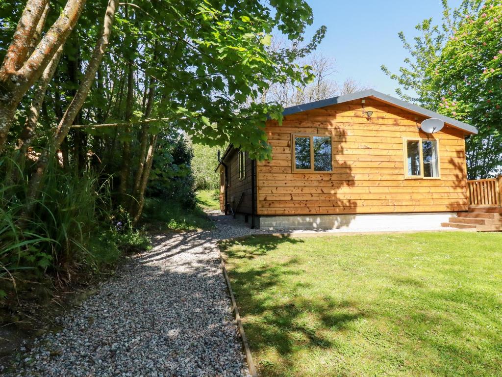 una pequeña casa de madera con un camino de grava delante de ella en Lodge Two en Truro