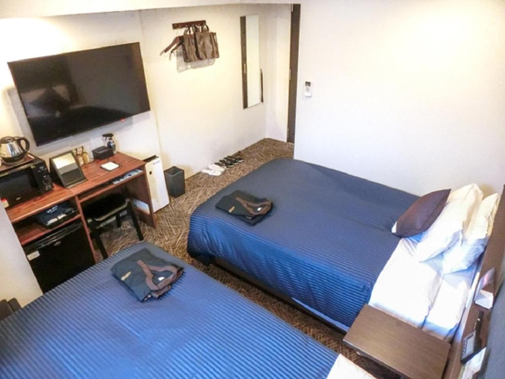 Postel nebo postele na pokoji v ubytování Natural Hot Spring Hotel Livemax Premium Hiroshima
