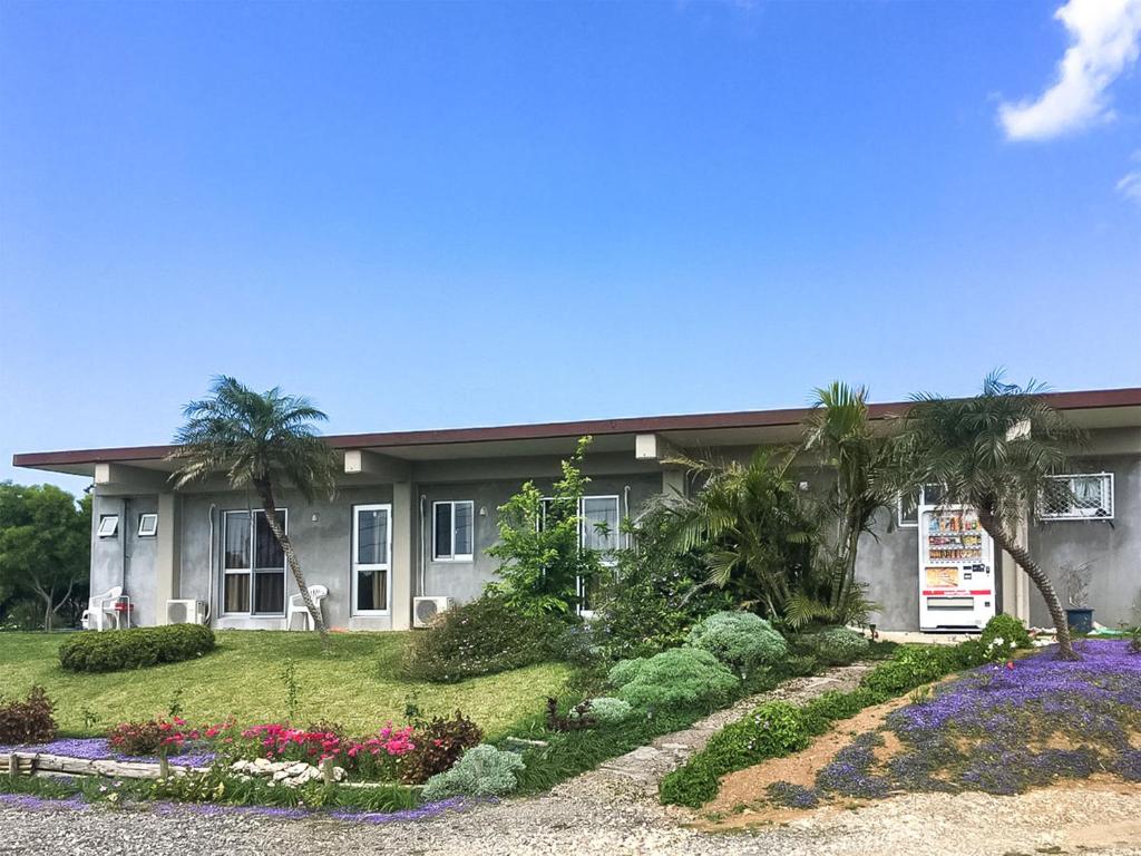 une maison avec un jardin en face dans l'établissement Pension Ntsunaka, à Île Miyako