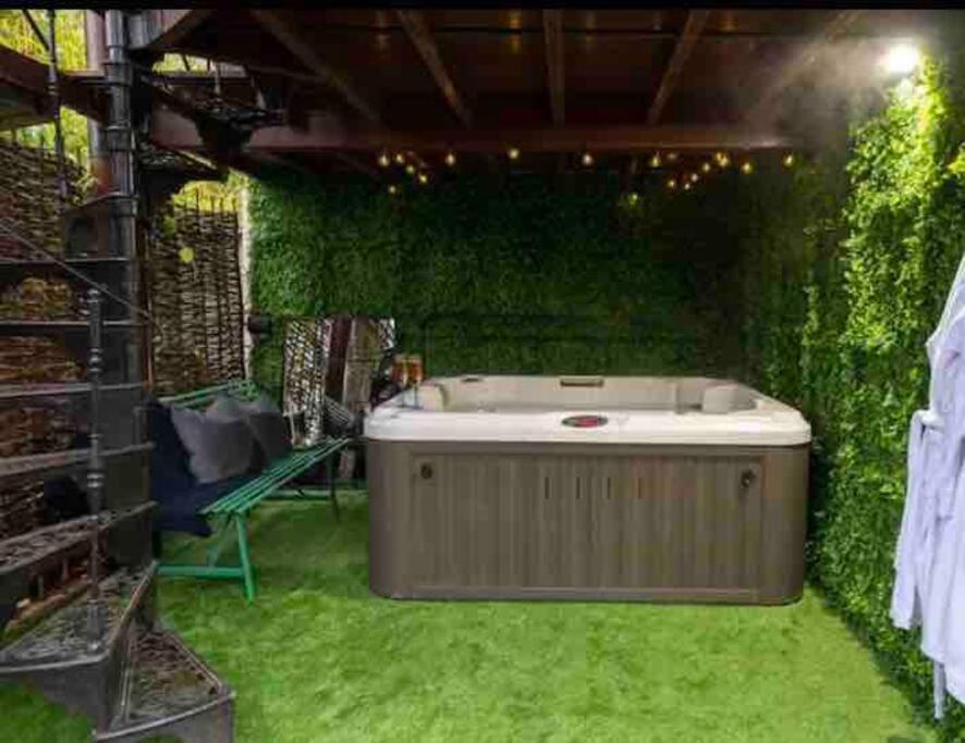 wanna z hydromasażem w pokoju z zielonym bluszczem w obiekcie Stunning home with hot tub in picturesque village w mieście Haddenham