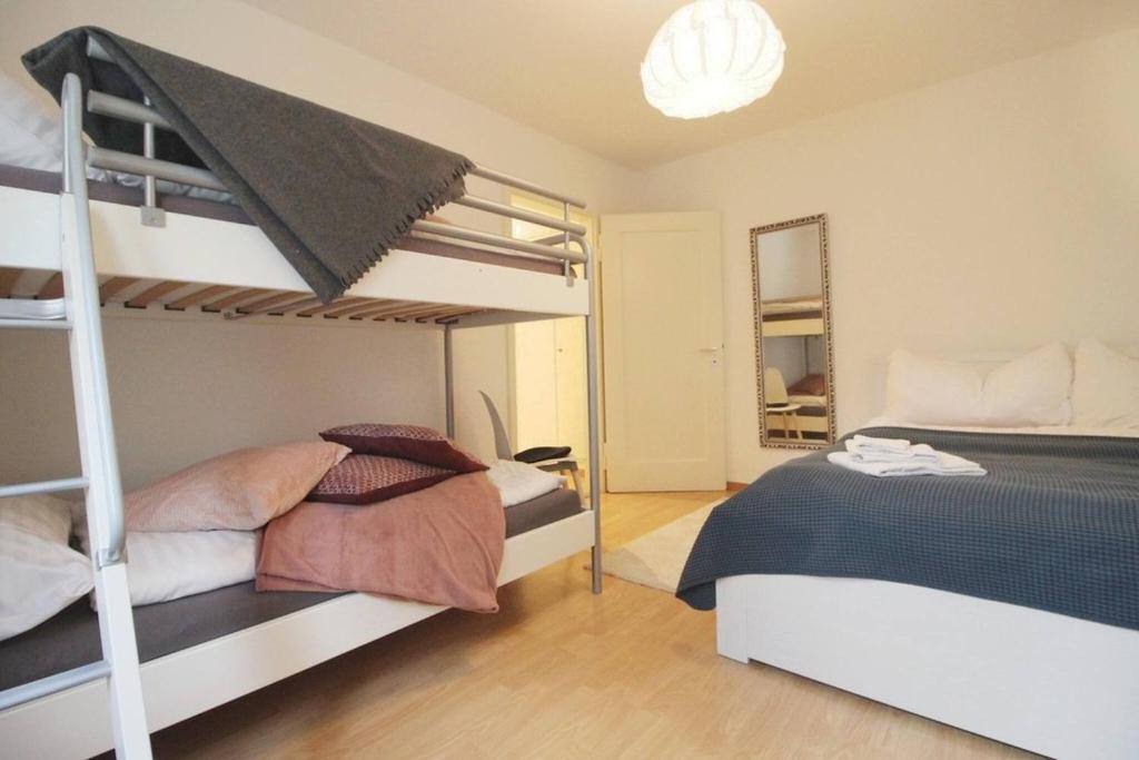 a bedroom with two bunk beds and a mirror at Nice apartment with sun terrace in St. Gallen