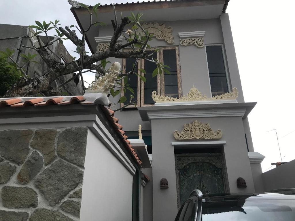 a white house with a window and a fireplace at Most Bali Malioboro Villa in Yogyakarta