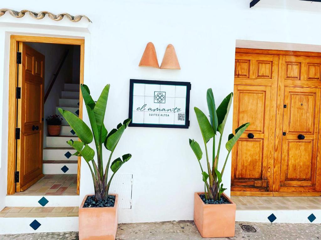 two plants in pots in front of a door at El amante Altea in Altea