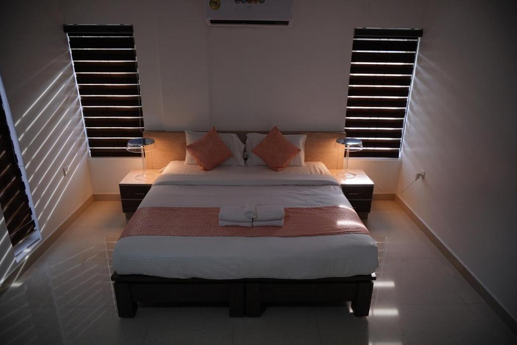 1 dormitorio con 1 cama grande y 2 ventanas en Chandra Inn, en Kollam