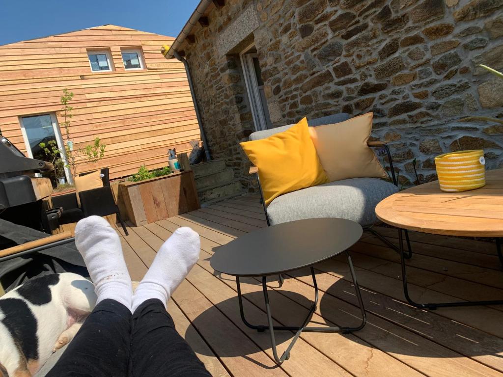 a person with their feet up on a patio at Kartier chambre deluxe in Plouguenast