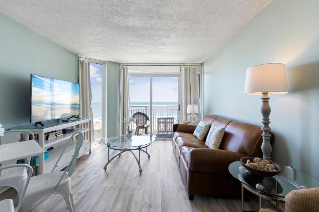 a living room with a couch and a table at Hosteeva 1BR Oceanfront Condo in Atlantica Resort near Boardwalk in Myrtle Beach