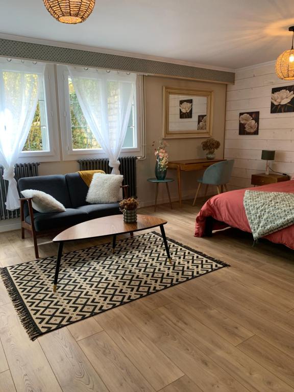 Sala de estar con cama, sofá y mesa en Au fil de l’eau, en Saint-Gelais