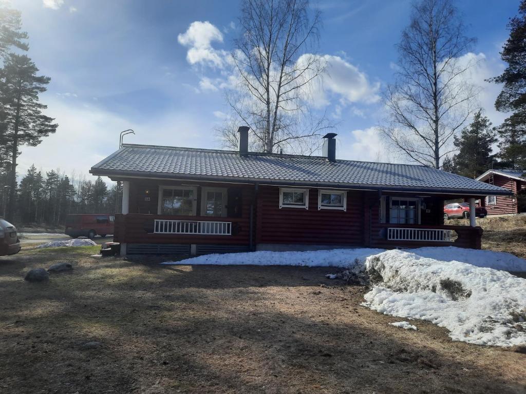 a log cabin with snow in front of it at Pankkotupa 8B in Punkaharju