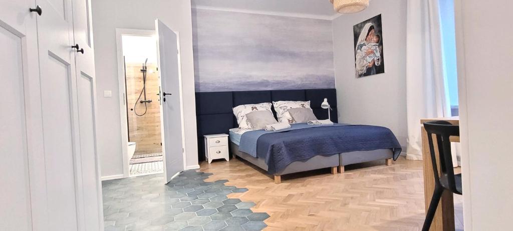 een slaapkamer met een bed met een blauwe sprei bij Kana Apartment Kraków Pomorska - close, fast WiFi, Smart TV in Krakau