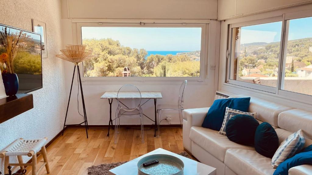 ein Wohnzimmer mit Couch und großem Fenster in der Unterkunft AZUR - Vue mer - Parking - Climatisation in Cassis