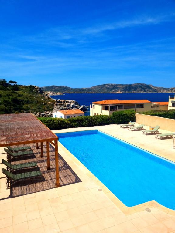 a swimming pool with a view of the ocean at Hôtel Sole Mare in Calvi