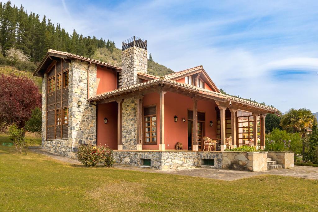 una casa grande con un color rojo en Exclusivo Chalet en Potes, en Potes