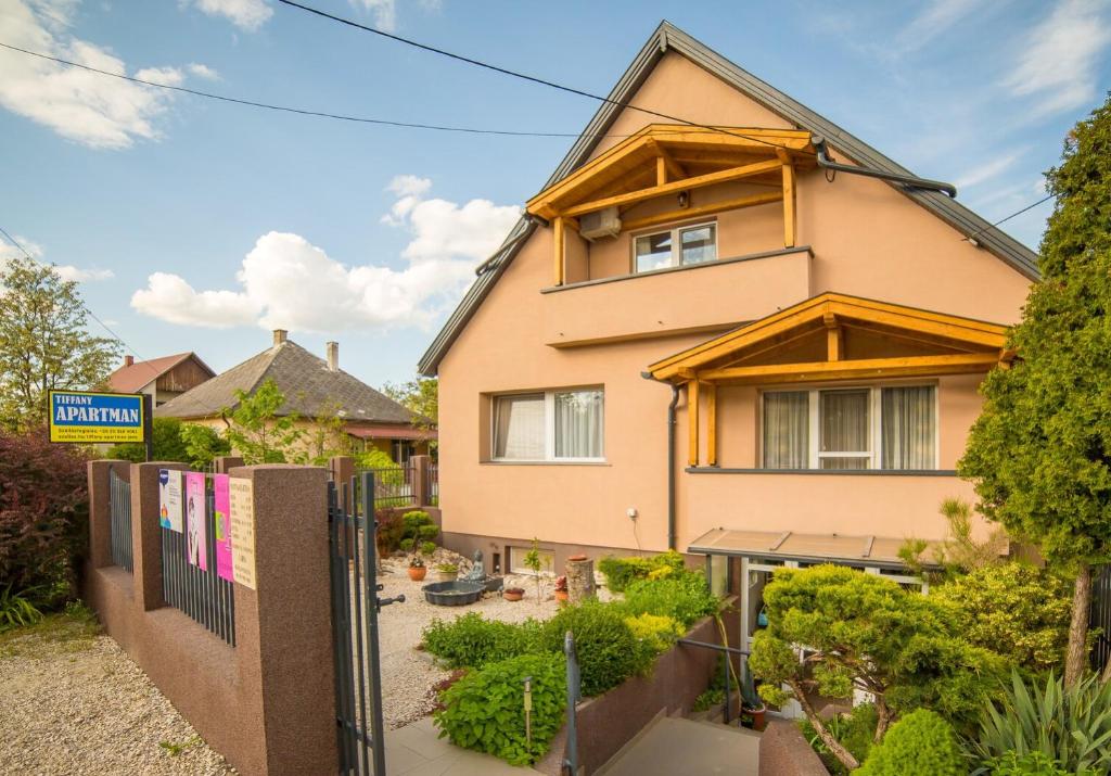 a house with a fence in front of it at TIFFANY Apartman in Jenő