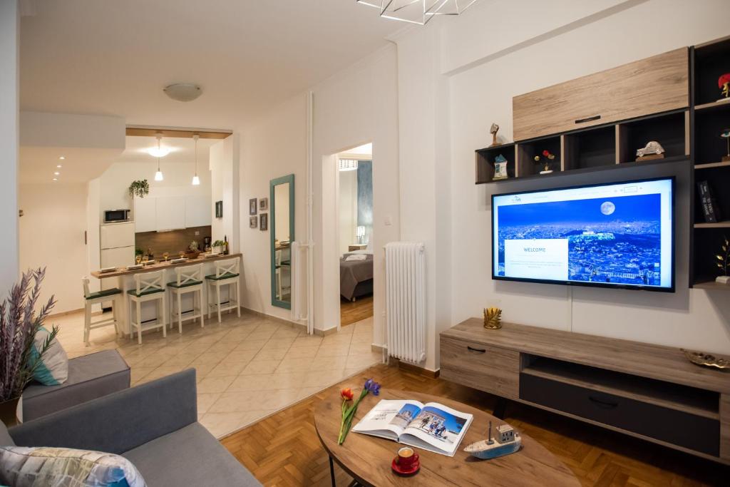 uma sala de estar com uma grande televisão de ecrã plano na parede em Blue Ark Comfort near Acropolis em Atenas