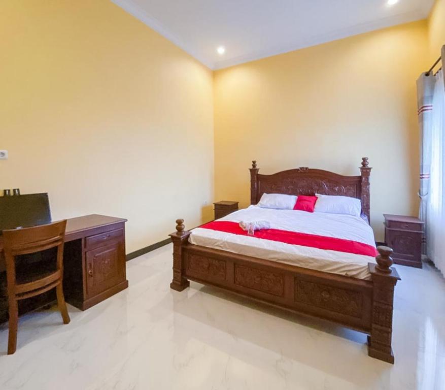 a bedroom with a wooden bed and a desk at RedDoorz Syariah near RSUD Kota Malang in Bareng