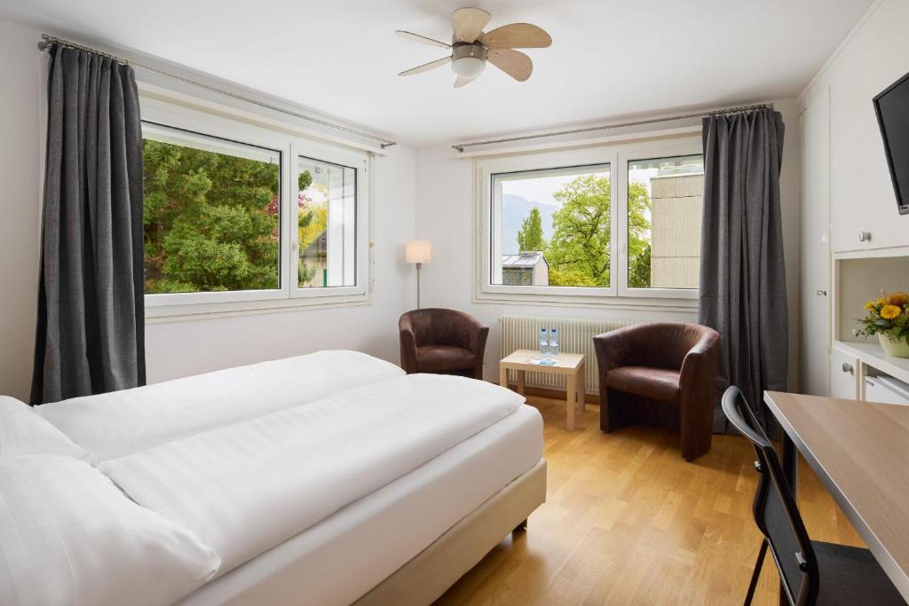 um quarto de hotel com uma cama, uma mesa e cadeiras em Bon Port em Montreux