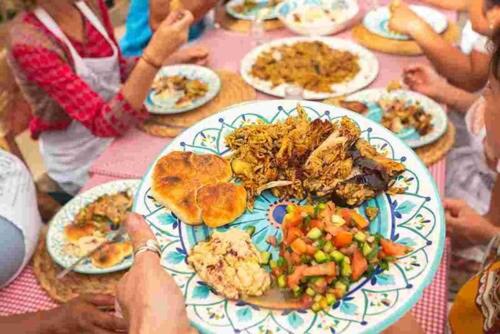 a group of people sitting at a table with a plate of food at Luner Camp at Wadi Rum in Wadi Rum