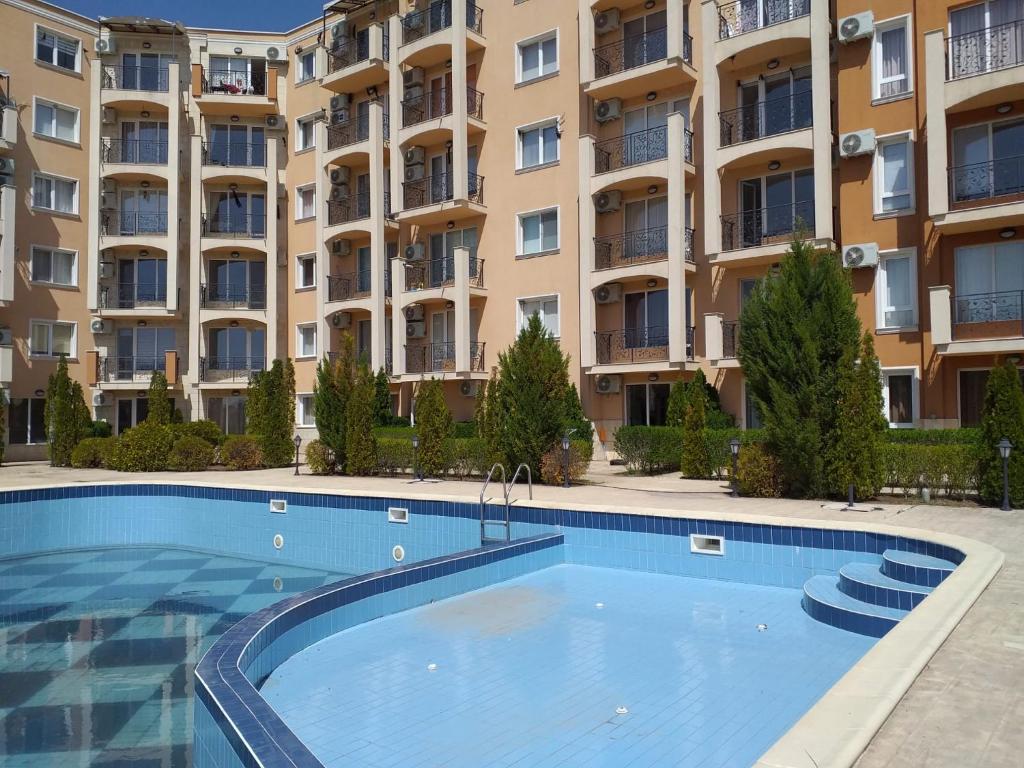 a swimming pool in front of a large apartment building at Byala COZY APARTMENT in Byala