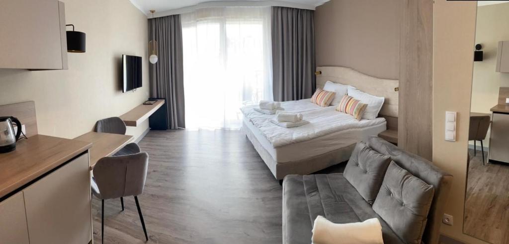 a living room with a bed and a couch at Bel Mare Apartament E338 FREE PARKING in Międzyzdroje
