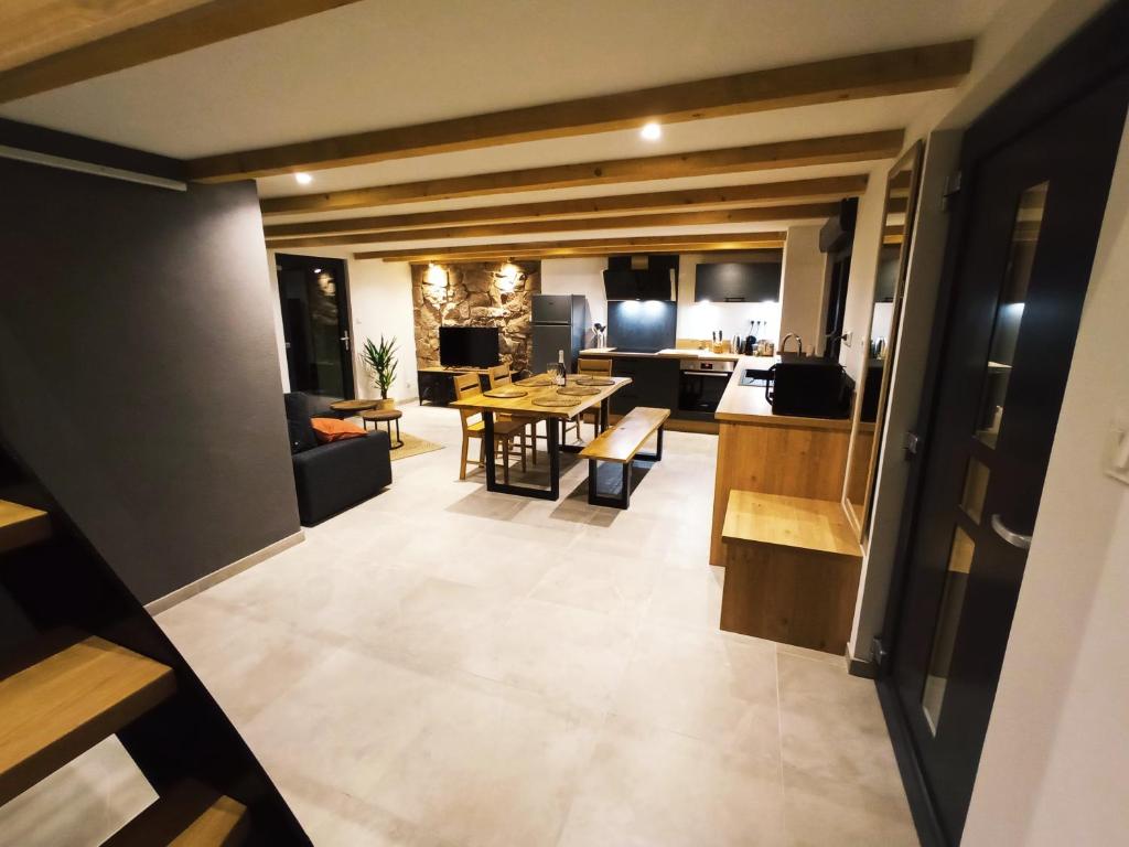 Vistas a la cocina y a la sala de estar. en Gîte des trois châteaux, en Husseren-les-Châteaux