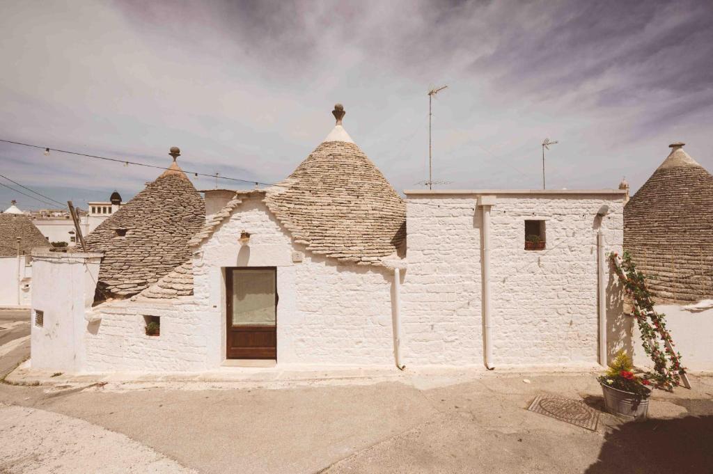 een wit gebouw met een dak met twee torens bij Trullo 100 Passi in Alberobello