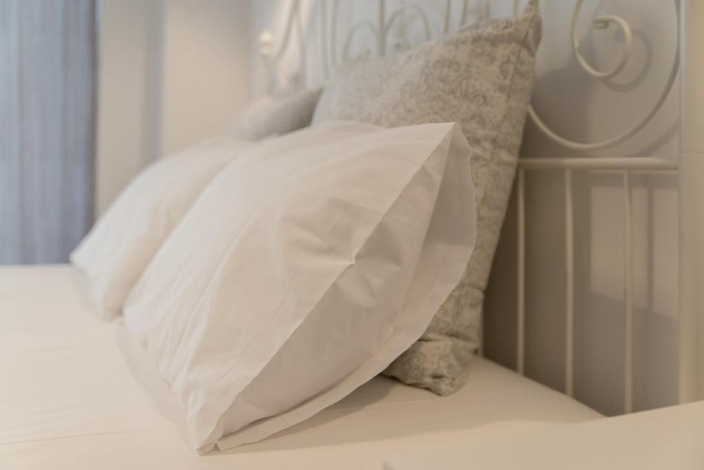 un cuscino bianco su un letto con cuscini di Amazing apartment 2 min to Acropolis ad Atene