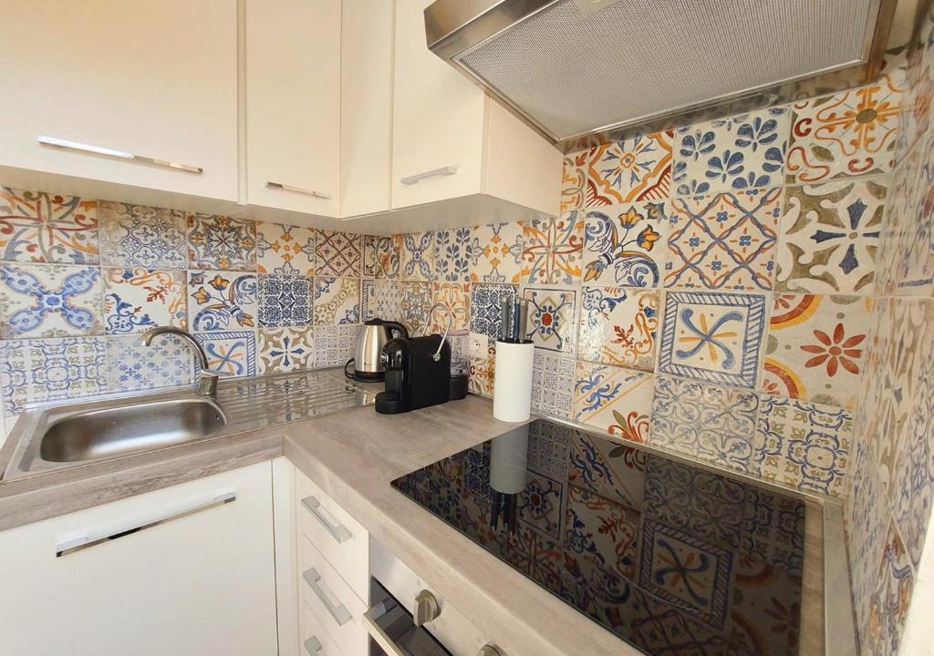 kuchnia ze zlewem i płytkami na ścianie w obiekcie Casa Valeria w mieście Porto Santo Stefano