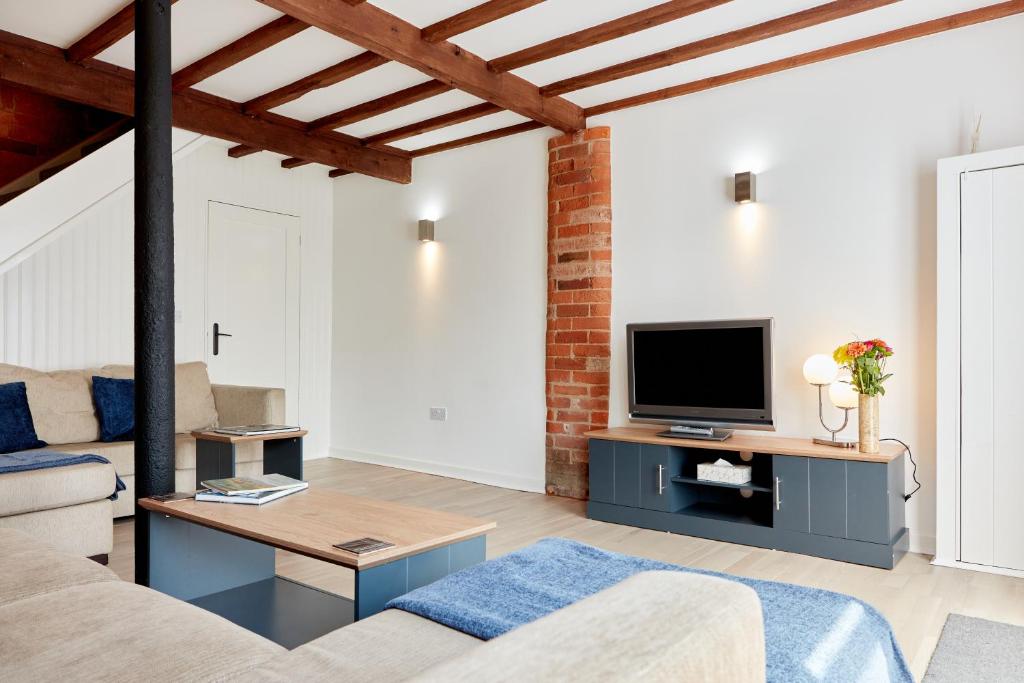 sala de estar con sofá y TV en Finest Retreats - The Pig Barn, en Ashbourne