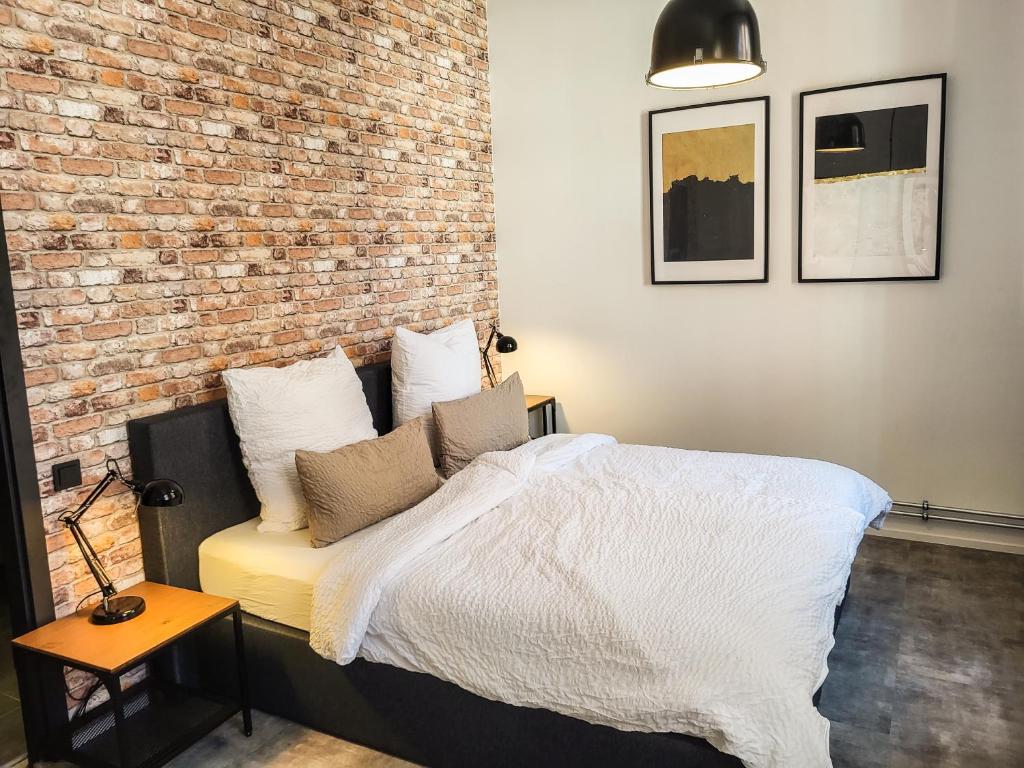 ブランデンブルク・アン・デア・ハーフェルにあるFerienwohnung Backstubeのレンガの壁のある部屋にあるベッド