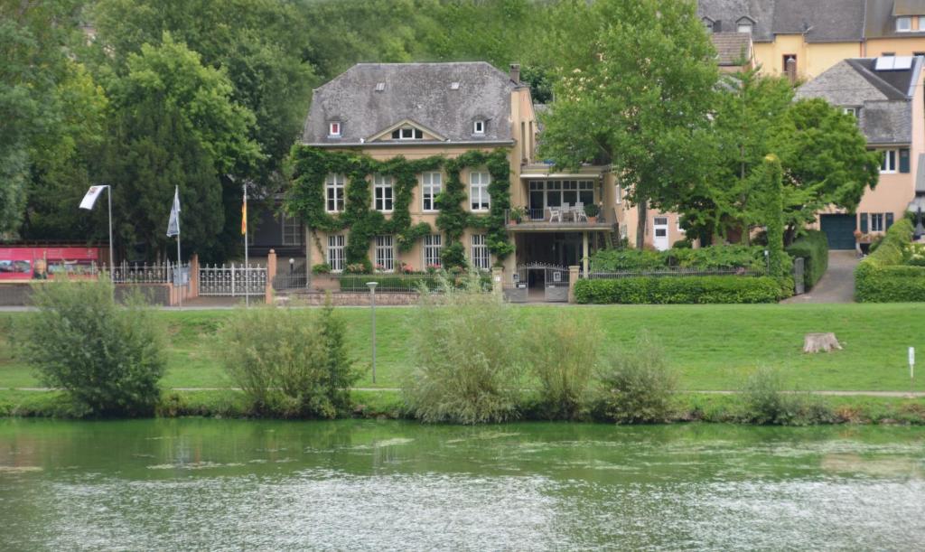 ein großes Haus neben einem Wasserkörper in der Unterkunft Ferienlodge von Scotti in Neumagen-Dhron