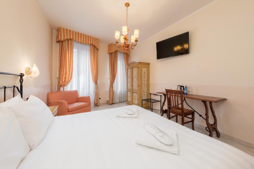 a bedroom with a large white bed and a desk at La Locandiera in Venice