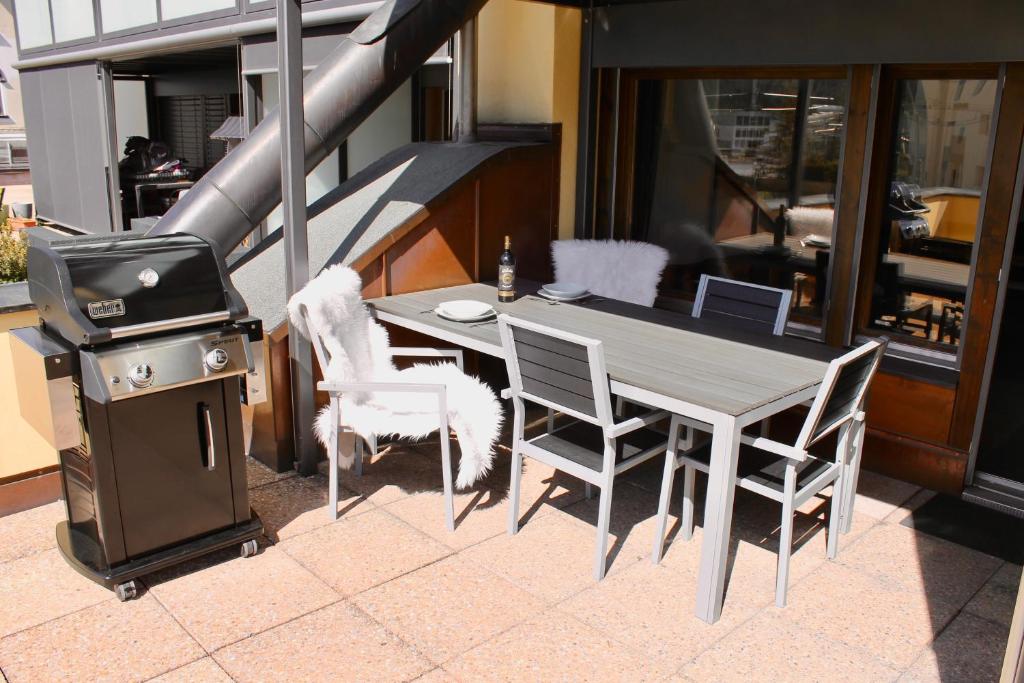 a grill and a table and chairs on a patio at Residenz Davos von Swisspartments in Davos