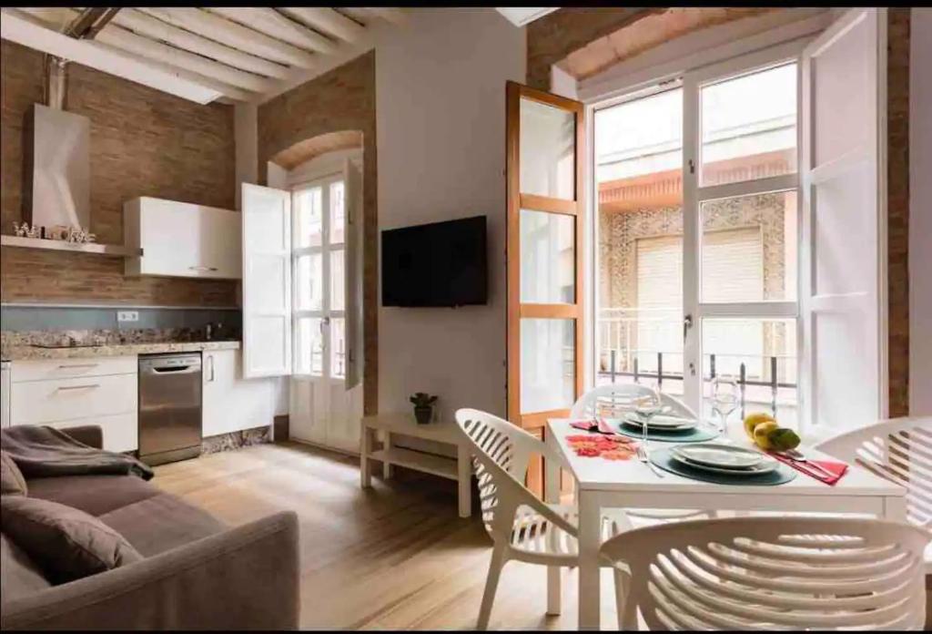 a kitchen and living room with a table and chairs at Increíble Apto1º San Miguel-Centro-Catedral-Wifi-Parking in Granada