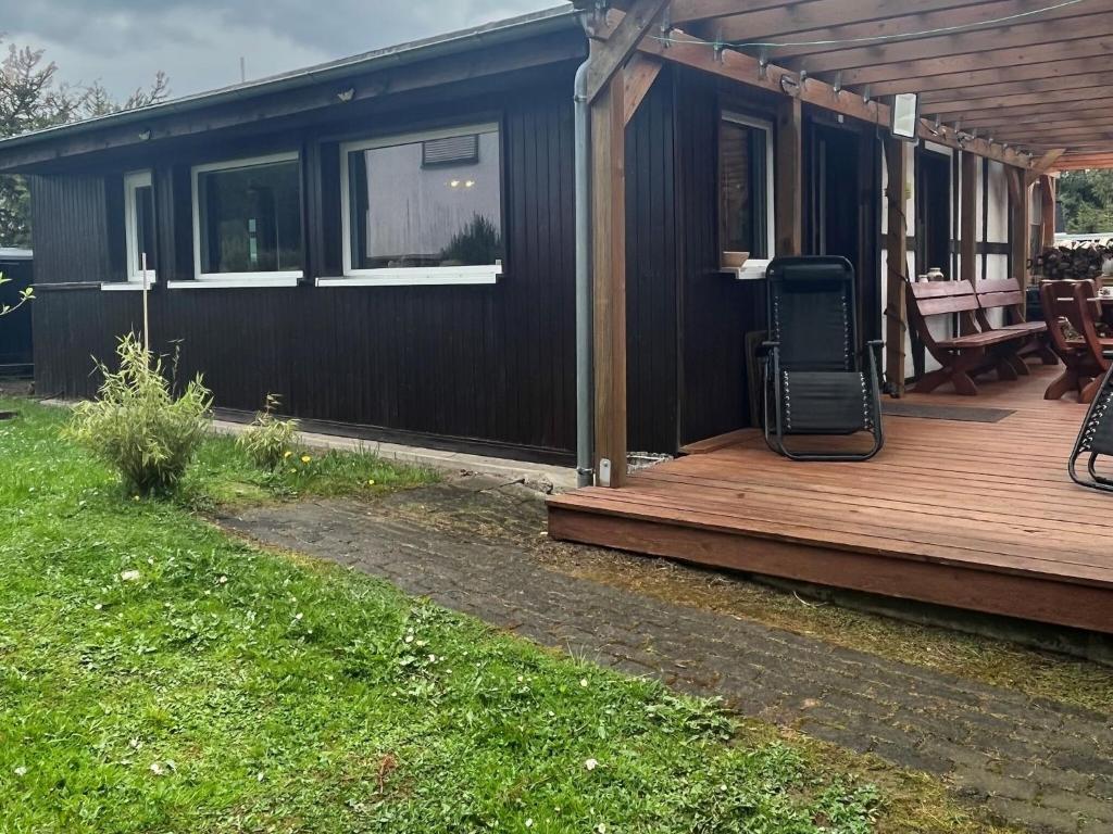 een huis met een houten terras met een grill bij Luxury villa in Tinjan with private pool in Harzgerode