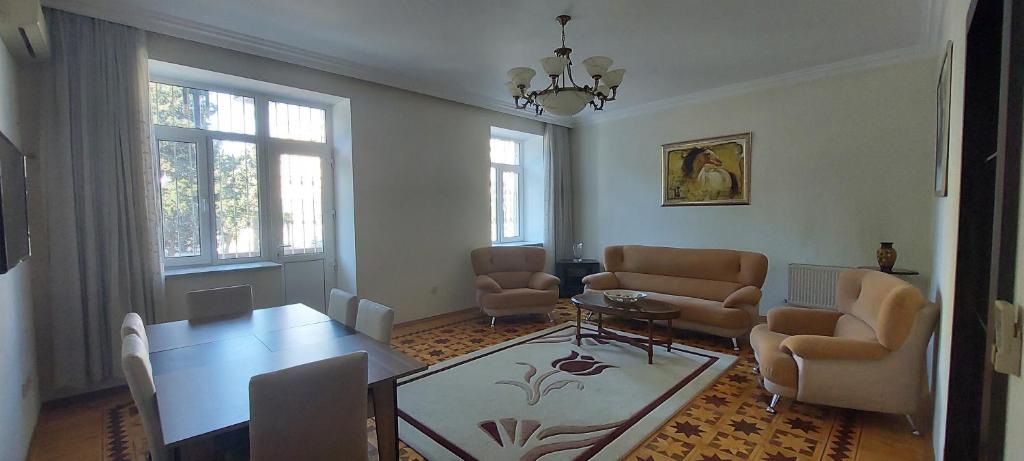 - un salon avec une table et des chaises dans l'établissement Azneft Royal Suite Apartment Sea View, à Baku