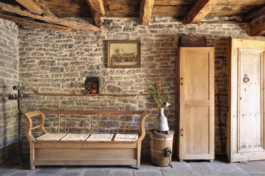 a wooden bench in a room with a brick wall at Avragonio in Papingo