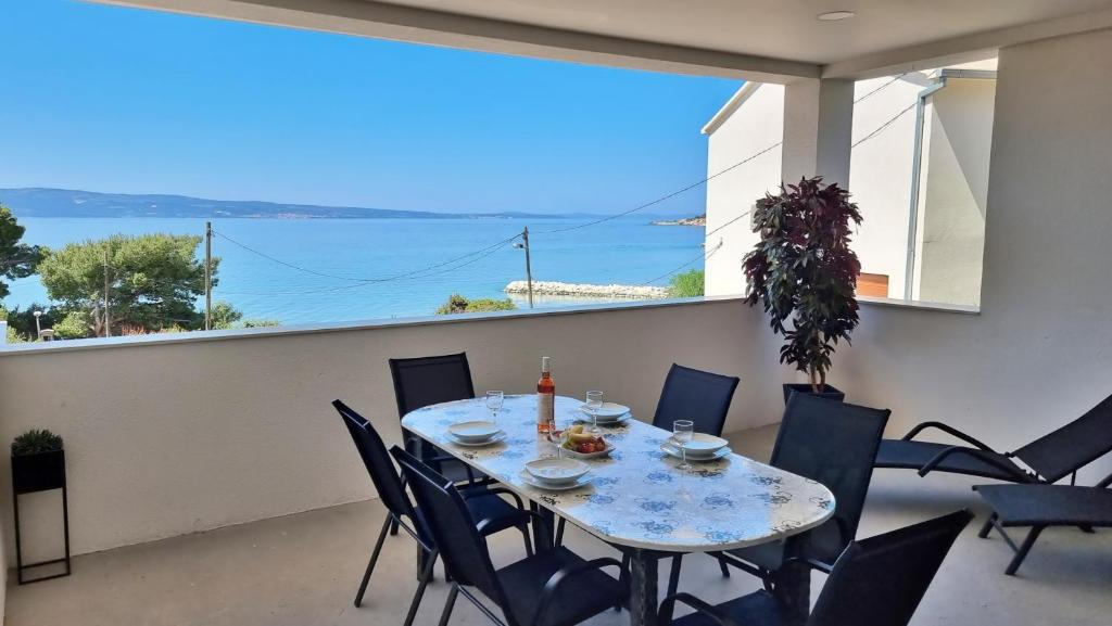 a table on a balcony with a view of the ocean at Apartment Milana in Duće