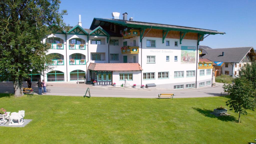 ein großes weißes Gebäude mit einem Park davor in der Unterkunft Voralpenhotel Schmoller in Sankt Georgen im Attergau