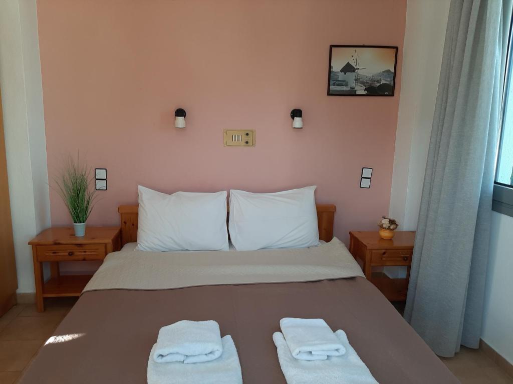 a bedroom with a bed with two towels on it at Ostria in Agia Galini