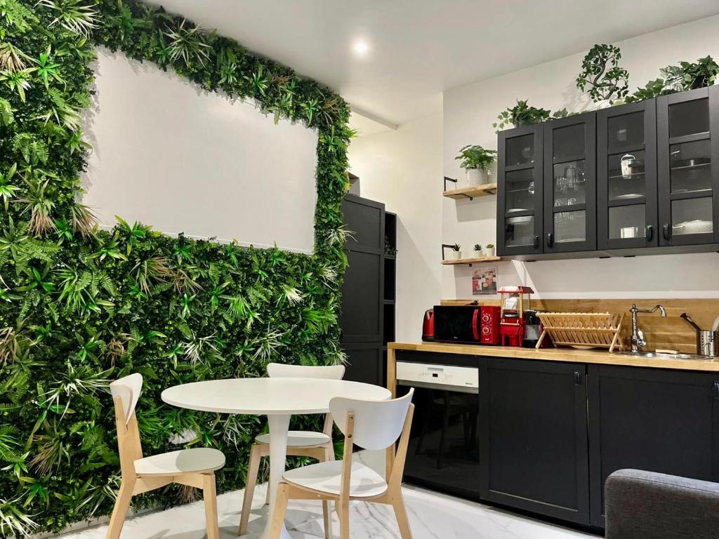 a kitchen with a green wall with a table and chairs at Haut Standing proche gare in Rouen