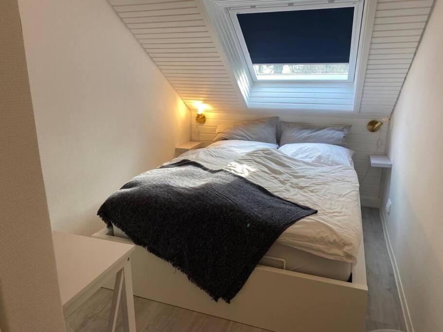 Bett in einem kleinen Zimmer mit Fenster in der Unterkunft Sand & Soul in Scharbeutz